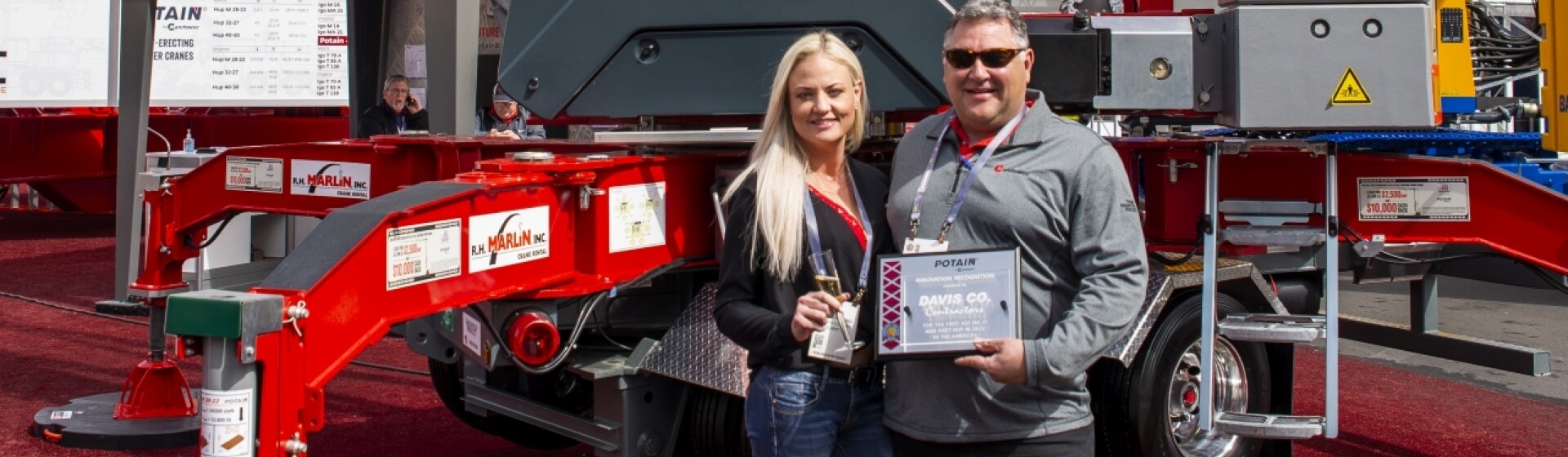 Dennis Davis, founder and owner of Davis Company, and Ashley Young celebrate the company’s new Potain Hup M 28-22 crane at CONEXPO 2020. Davis-Company-first-Hup-M-28-22-self-erecting-tower-crane-in-North-America-1.jpg