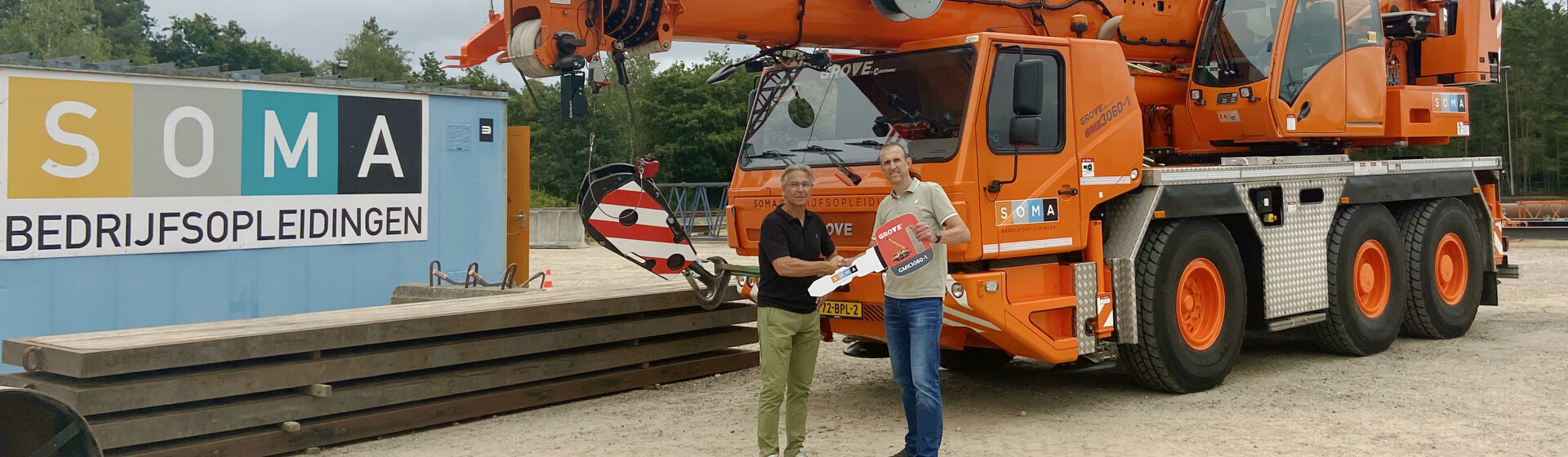 Erik Baas of Manitowoc (left) and Jeroen Boekelo of SOMA (right) celebrate the delivery of the Grove GMK3060-1. Netherlands-training-facility-chooses-Grove-GMK3060-1-for-new-operators-01.jpg