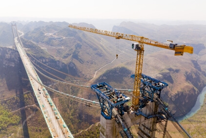 The Potain MCT 385 standing tall over the Huajiang Grand Canyon, supporting construction of the world’s tallest bridge. Potain-MCT-385-hits-new-heights-on-worlds-tallest-bridge-1.jpg